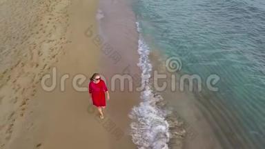 一个女人赤脚走在潮湿<strong>的沙滩上的</strong>俯视图。 海浪冲刷着<strong>沙滩上的脚印</strong>